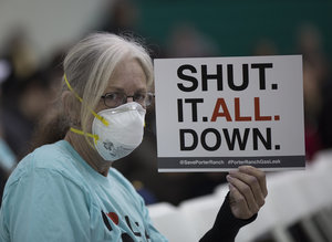 PORTER RANCH, CA - JANUARY 16:  A woman holds a sign while attending a public hearing before the South Coast Air Quality Management District (AQMD) regarding a proposed stipulated abatement order to stop a nearby massive natural gas leak, on January 16, 2016 in Granada Hills, near Porter Ranch, California. More than 80,000 metric tons of methane gas have spewed from the Aliso Canyon natural gas storage facility since October 23, causing thousands of Porter Ranch residents to leave their homes, and the closures of two schools where students are being bussed to campuses farther away from the gas. State officials are now concerned that a seventh attempt to plug the well may have increased the chance of a blowout, which would greatly increase the release of gas as well as the risk of a massive well fire if ignited by a spark. The Southern California Gas Company (SoCalGas) hopes to repair the leak by sometime in March.  (Photo by David McNew/Getty Images)