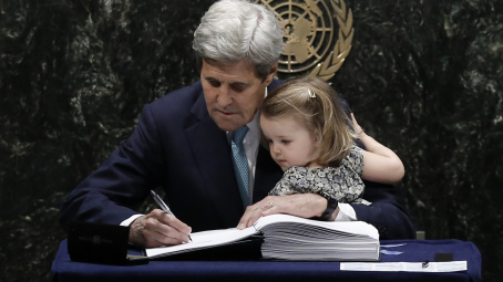 U.S. Secretary of State John Kerry holds his two-year-old granddaughter Isabelle Dobbs-Higginson as he signs the Paris Agreement on climate change at United Nations Headquarters in Manhattan, New York, U.S., April 22, 2016.    REUTERS/Mike Segar  - RTX2B8C9
